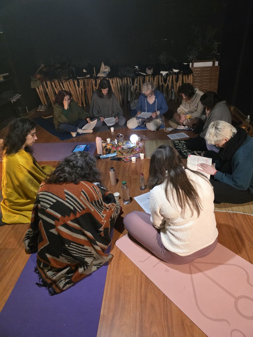 Roda de mulheres sentadas no chão, lendo juntas